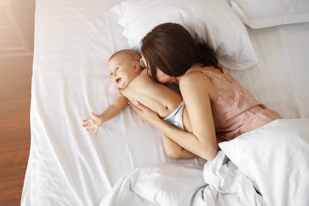 mother and colic baby in bed 