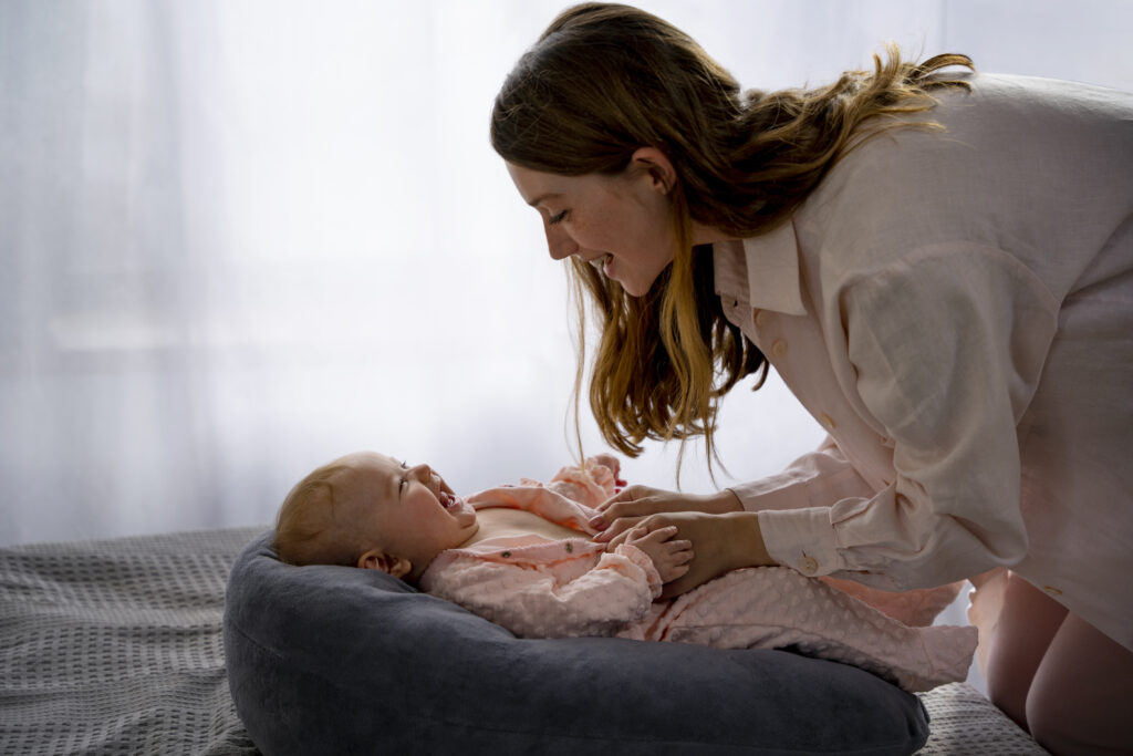 Mother soothing baby during light sleep phase, part of baby sleep cycles explained in understanding sleep associations