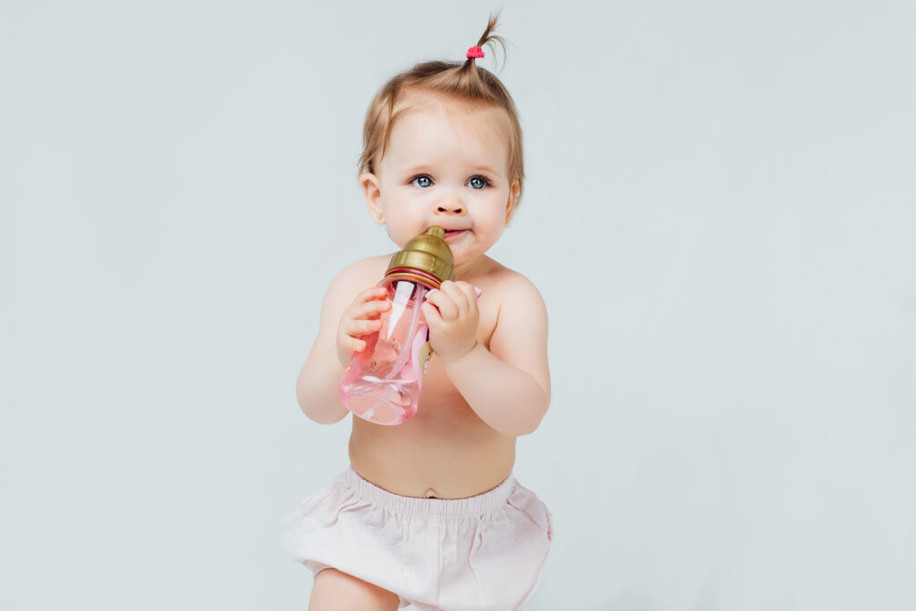 Baby learning to sip water during meals after starting solids.