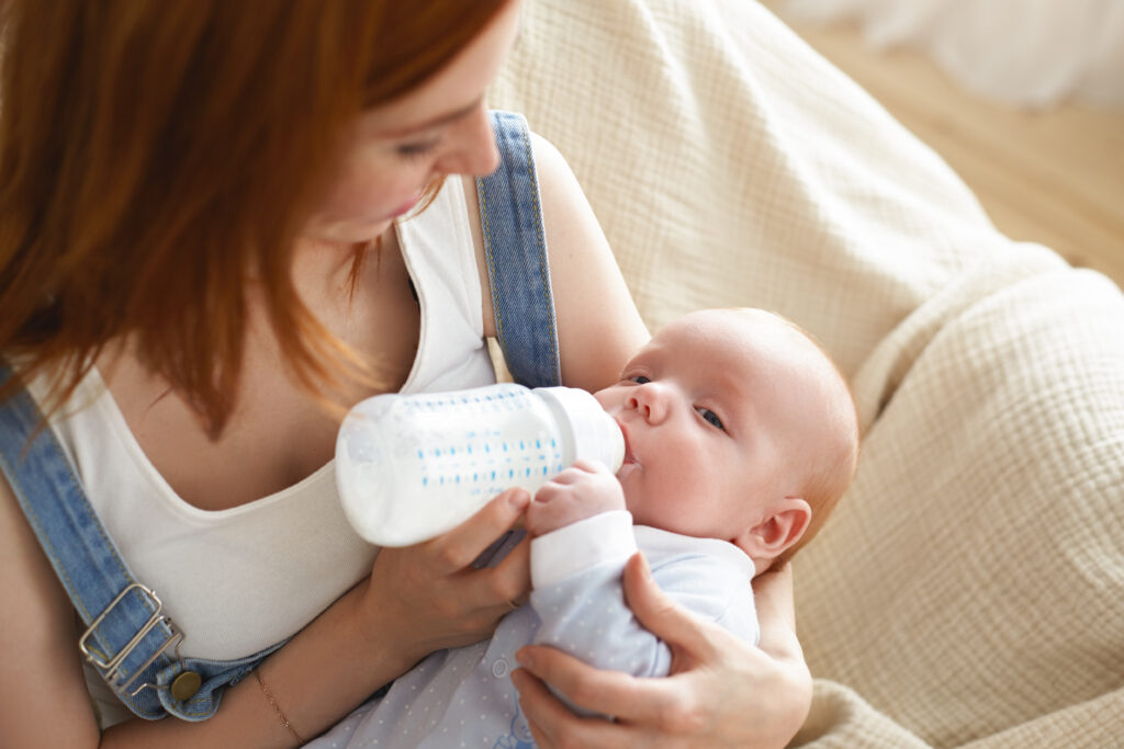 Mother bottle-feeding her baby as part of a balanced routine alongside introducing solids