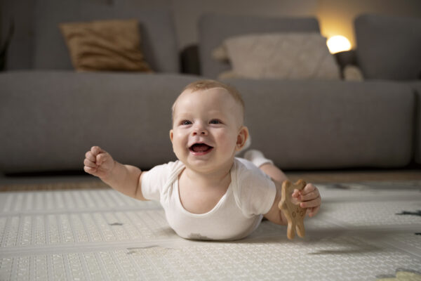 Baby practising tummy time on a play mat to build rolling skills